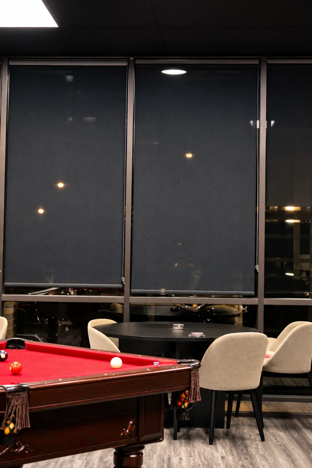 Red pool table beside lounge seating.